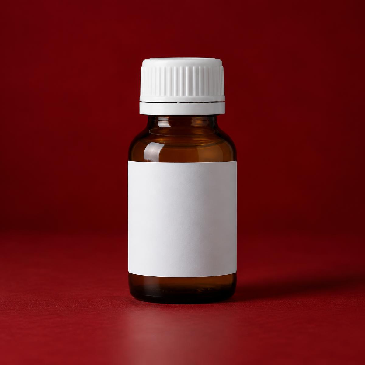 An amber pharmacy bottle with a plain white label on a dark red studio background